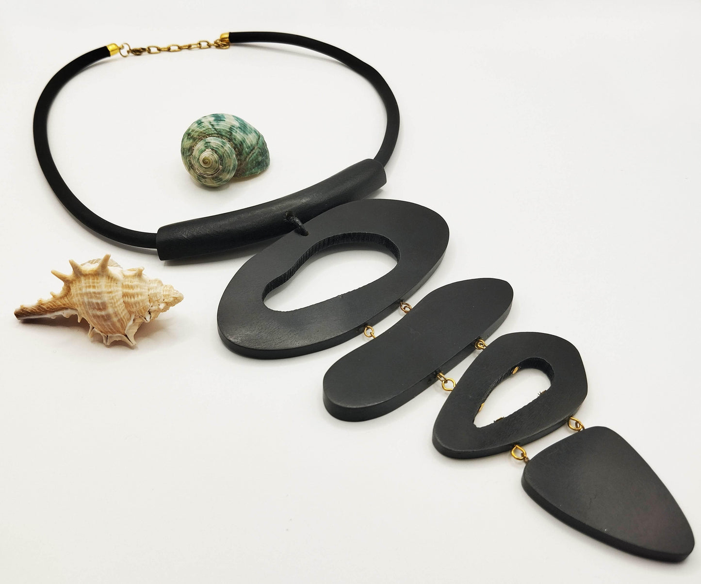 Μεγάλο κολιέ από λάστιχο και ξύλο μάνγκο με τέσσερα ασύμμετρα στοιχεία.
Είναι πολύ μοντέρνο κομμάτι, σχεδιασμένο να κάνει εντύπωση.