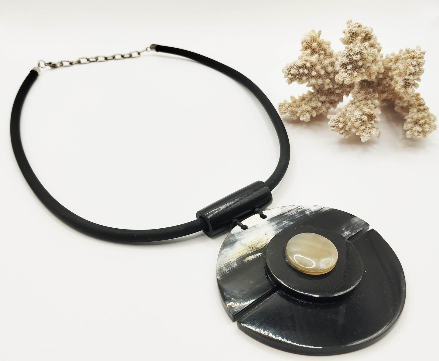 Μεγάλο κολιέ από λάστιχο και μενταγιόν από φυσικό κέρατο νεροβούβαλου.
Πολύ μοντέρνο κομμάτι που δεν περνάει απαρατήρητο.