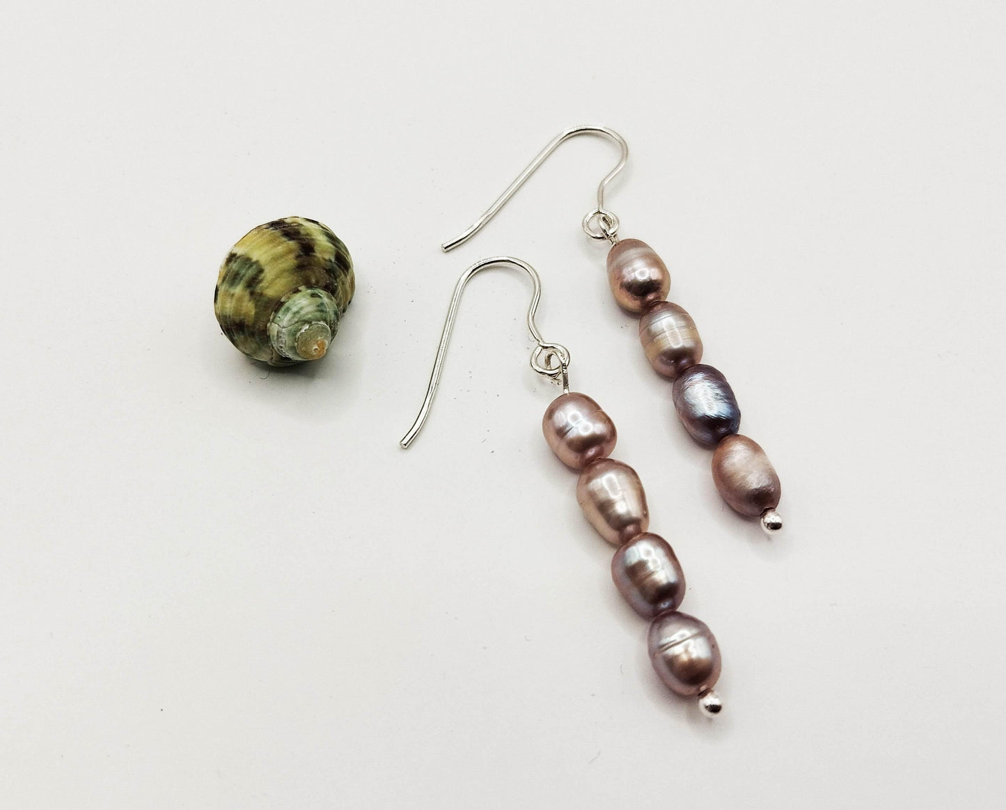 Ασημένια σκουλαρίκια με τέσσερα μαύρα μαργαριτάρια καλλιέργειας.
Κομψά, μοντέρνα και classy.