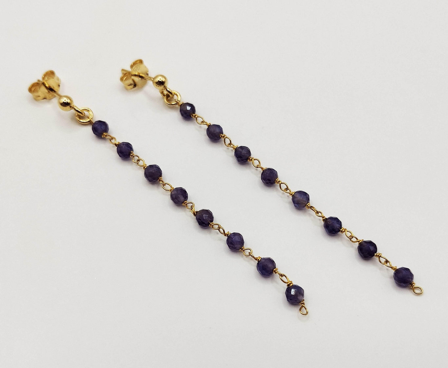 Σκουλαρίκια από επιχρυσωμένο ασήμι με μια σειρά από πετρούλες αμέθυστου.
Αυτό το ζευγάρι είναι λίγο πιο κοντό (66 mm) από τα "μακριά σκουλαρίκια με τυρκουάζ" μας, αλλά εξίσου όμορφο.