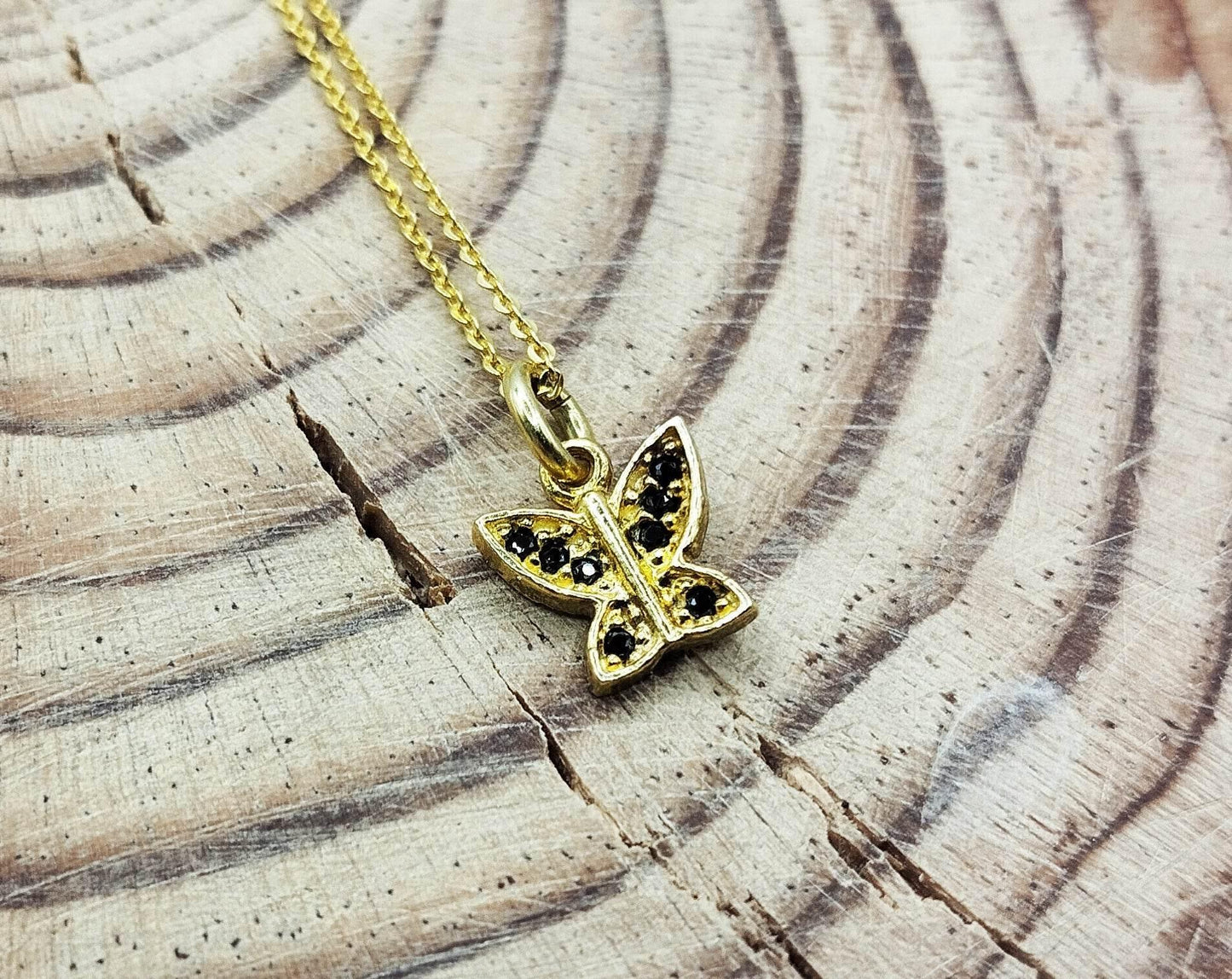 Κολιέ από επιχρυσωμένο ασήμι με επίχρυσο μενταγιόν σε σχήμα πεταλούδας με μαύρα ζιργκόν.