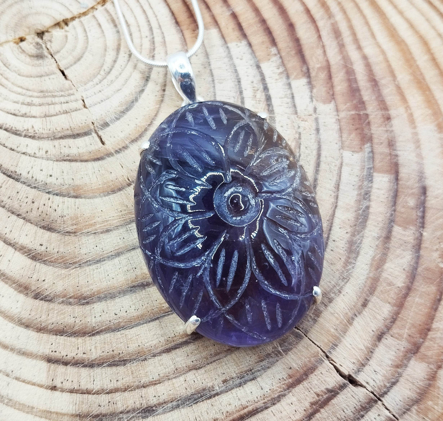 Ασημένιο κολιέ με μεγάλο μενταγιόν με αμετρίν (πέτρωμα που συνδυάζει αμέθυστο και σιτρίν) εγχάρακτο με σχέδιο λουλουδιού.