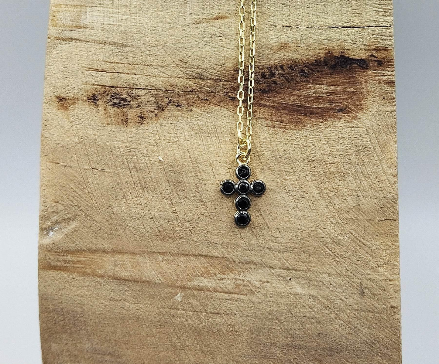 Κολιέ από επιχρυσωμένο ασήμι με επίχρυσο μενταγιόν σε σχήμα σταυρού με μαύρα ζιργκόν.