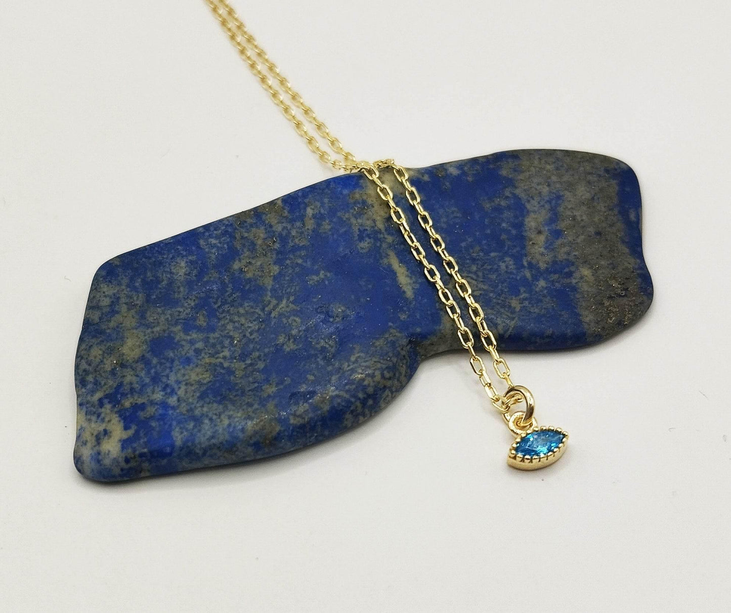 Κολιέ από επιχρυσωμένο ασήμι με επίχρυσο μενταγιόν σε σχήμα ματιού με γαλάζιο ζιργκόν.