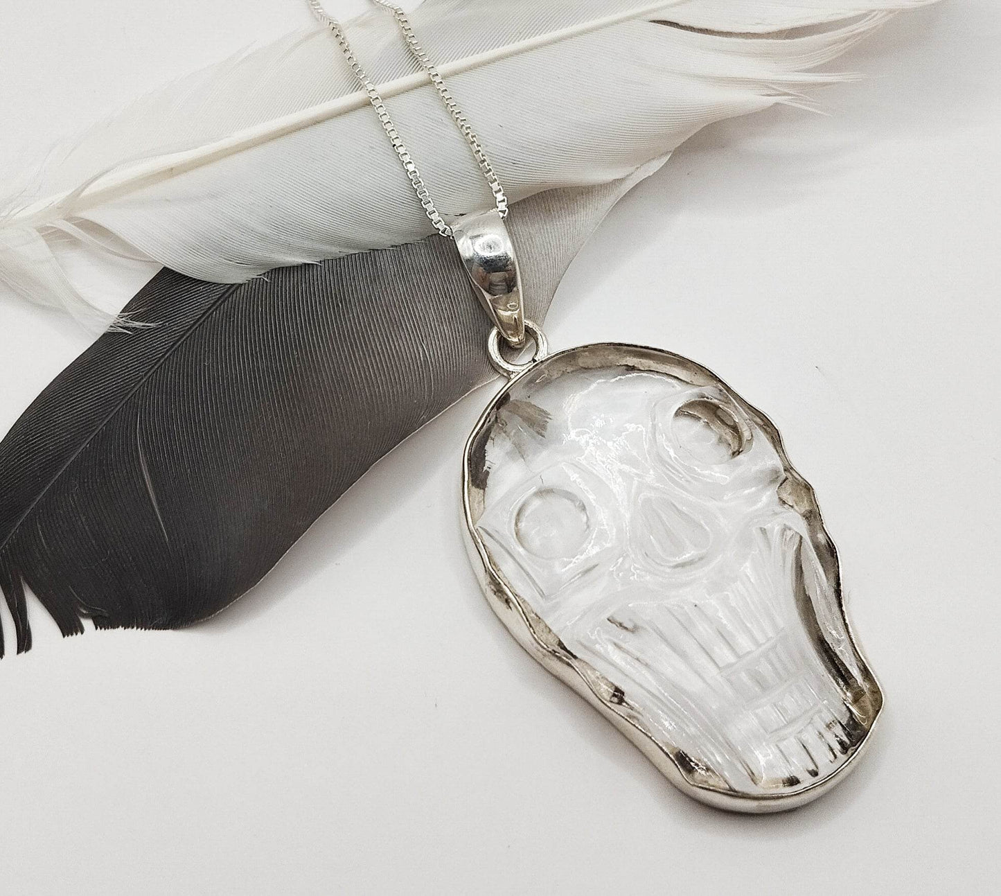 Ασημένιο κολιέ με μενταγιόν από λευκό χαλαζία σε σχήμα νεκροκεφαλής.