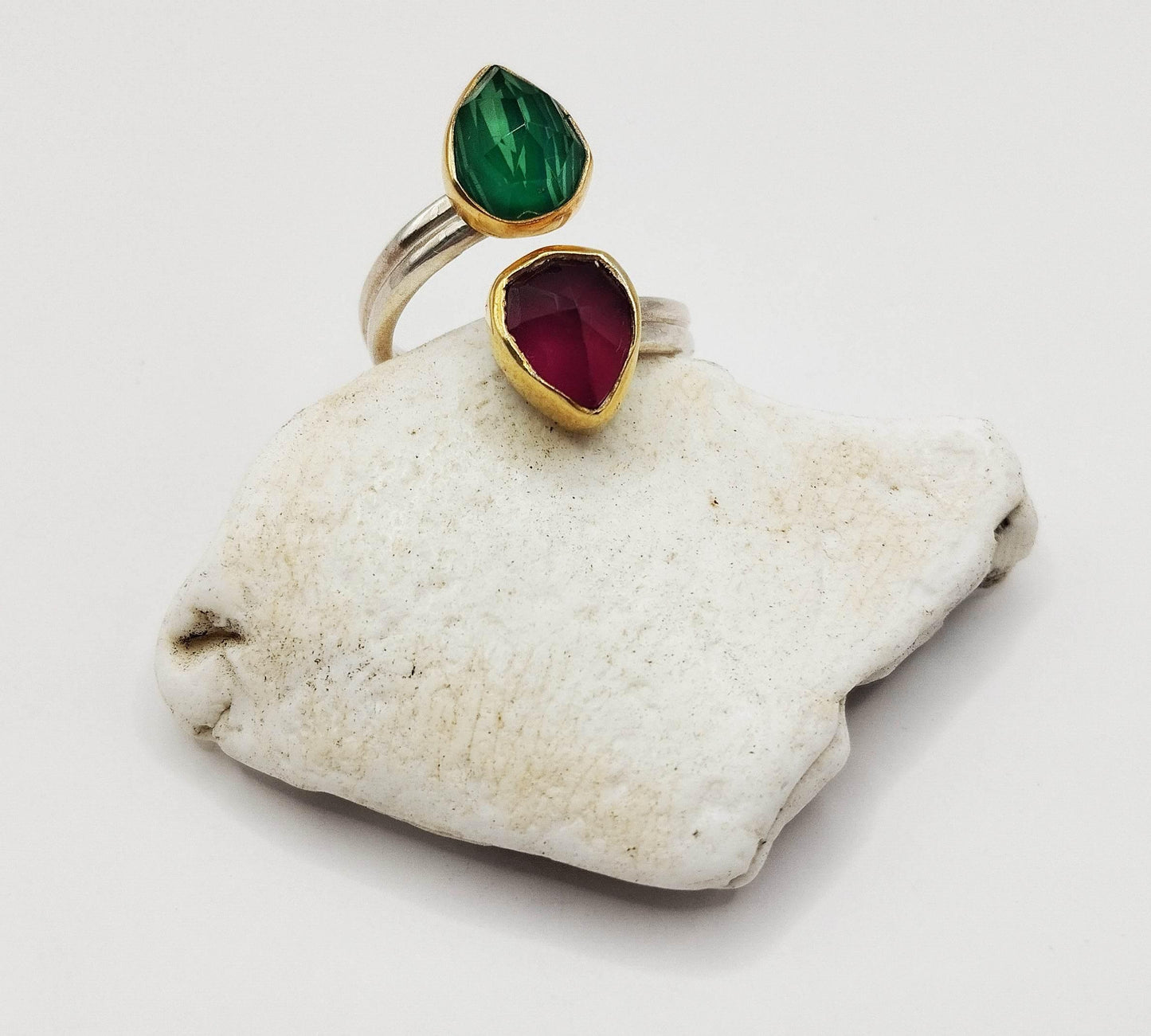 Ασημένο διαχτυλίδι με επίχρυσες λεπτομέρειες και δύο πέτρες από νεφρίτη - μία χρώματος μπορντώ, μία πράσινη - σε σχήμα σταγόνας.
Αυτό το υπέροχο δαχτυλίδι σας δίνει την επιλογή να το φορέσετε είτε με τη μπορντώ είτε με την πράσινη σταγόνα επάνω και δείχνει εξίσου ωραίο και στις δύο περιπτώσεις.