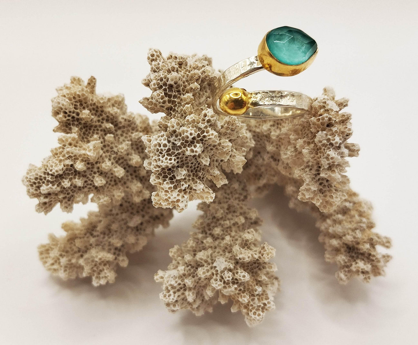 Ασημένιο δαχτυλίδι με επίχρυσες λεπτομέρειες και μια λαμπερή γαλάζια πέτρα τυρκουάζ σε σχήμα σταγόνας.
Το δαχτυλίδι αγκαλιάζει το δάχτυλο και σας δίνει τη δυνατότητα να έχετε είτε την πέτρα είτε τη χρυσή άκρη από πάνω.