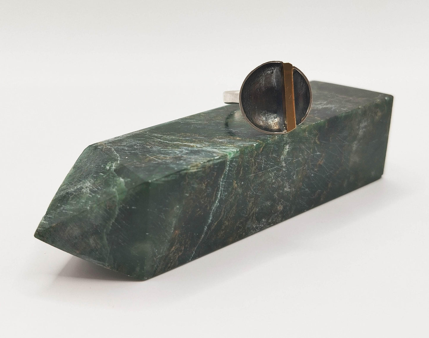 Ασημένιο δαχτυλίδι με κάθετο στοιχείο από μπρούντζο πάνω σε ασημένιο κυρτό δίσκο.
Μινιμαλιστικό ντιζάιν για πολύ μοντέρνο λουκ.