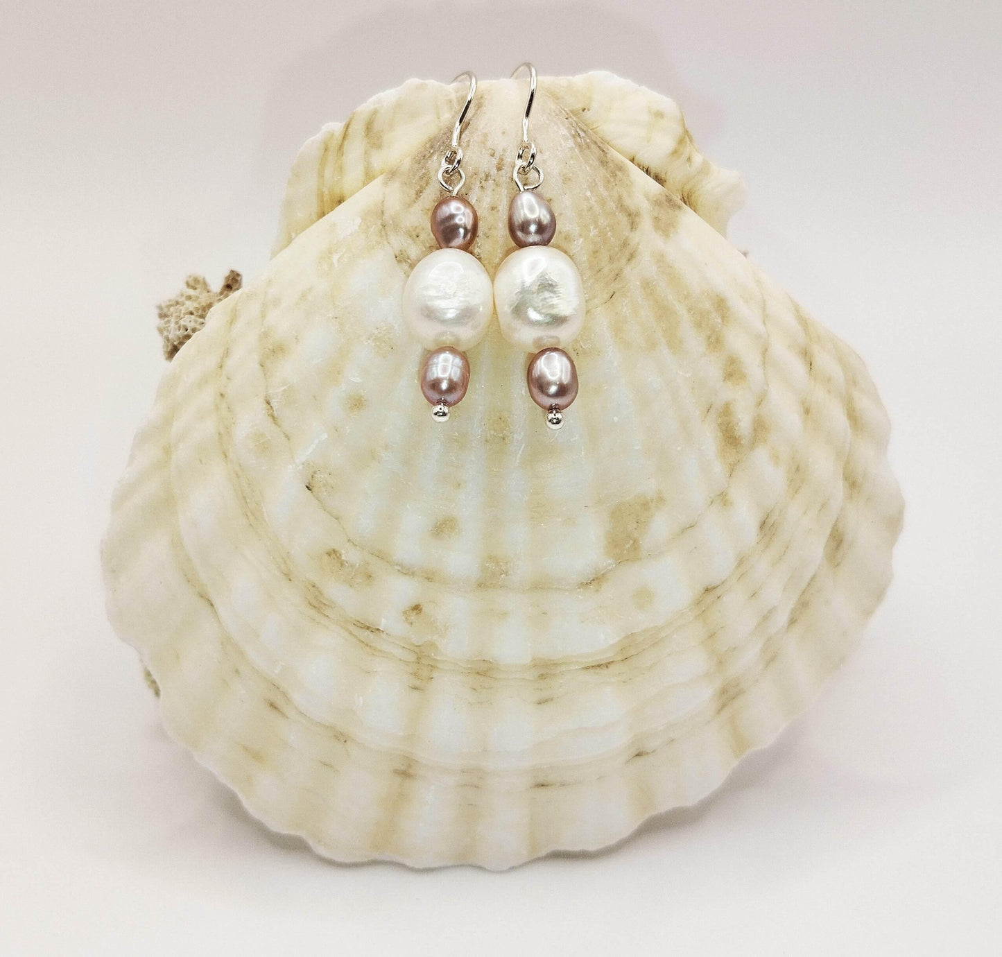 Ασημένια σκουλαρίκια με ένα ακανόνιστο μαργαριτάρι και δύο μικρότερα μαύρα μαργαριτάρια εκατέρωθεν.
Modern classic.