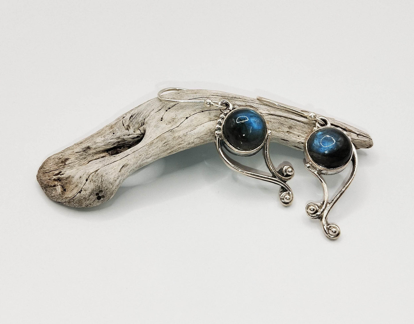 Ασημένια σκουλαρίκια με στρογγυλές πέτρες λαμπραδορίτη.
Σχηματίζουν ένα λεπτό, καμπυλωτό σχέδιο και λάμπουν χάρη στον ιριδισμό του λαμπραδορίτη.