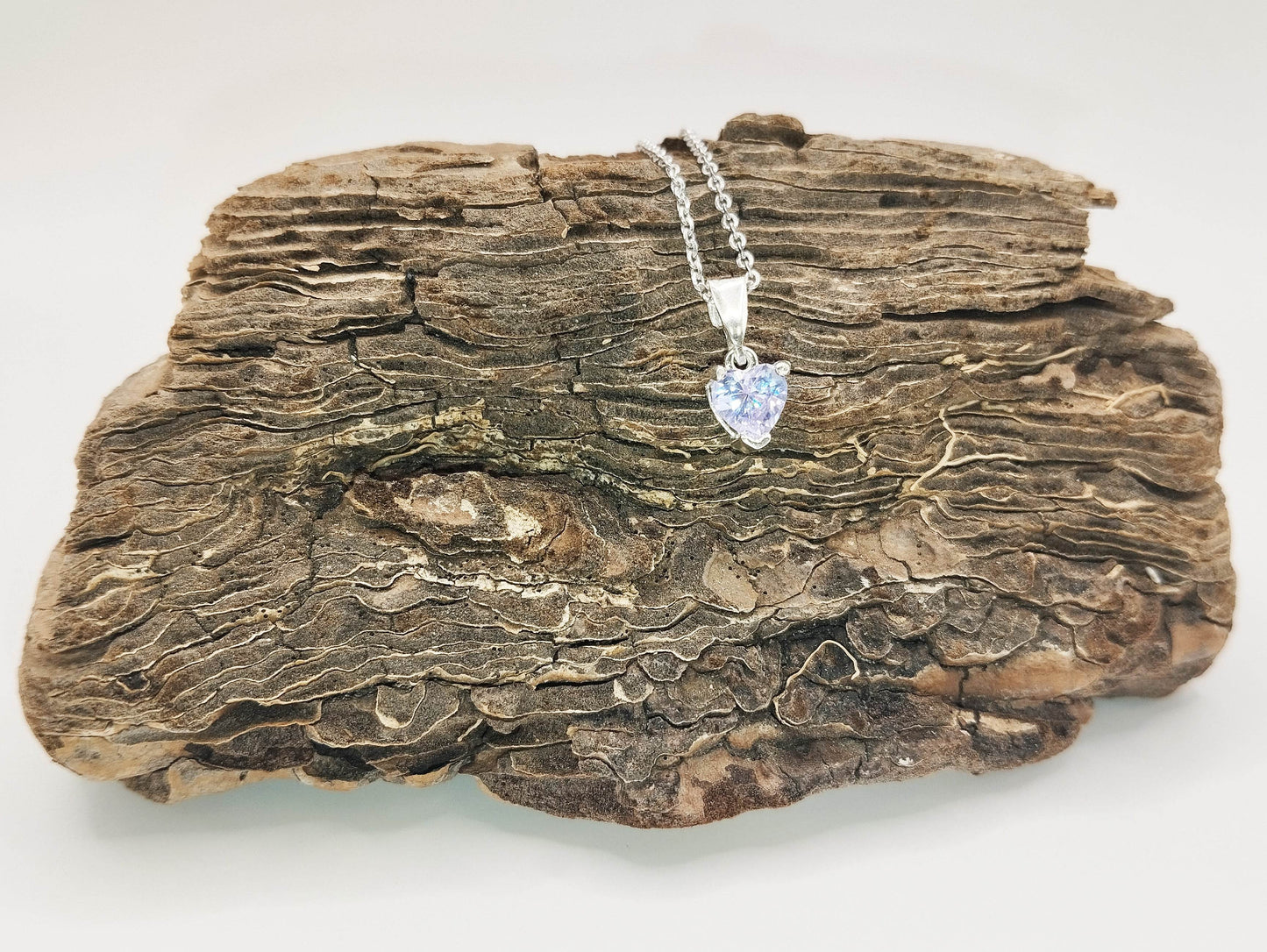 Ασημένιο κολιέ με μενταγιόν σε σχήμα καρδιάς από λιλά ζιργκόν.