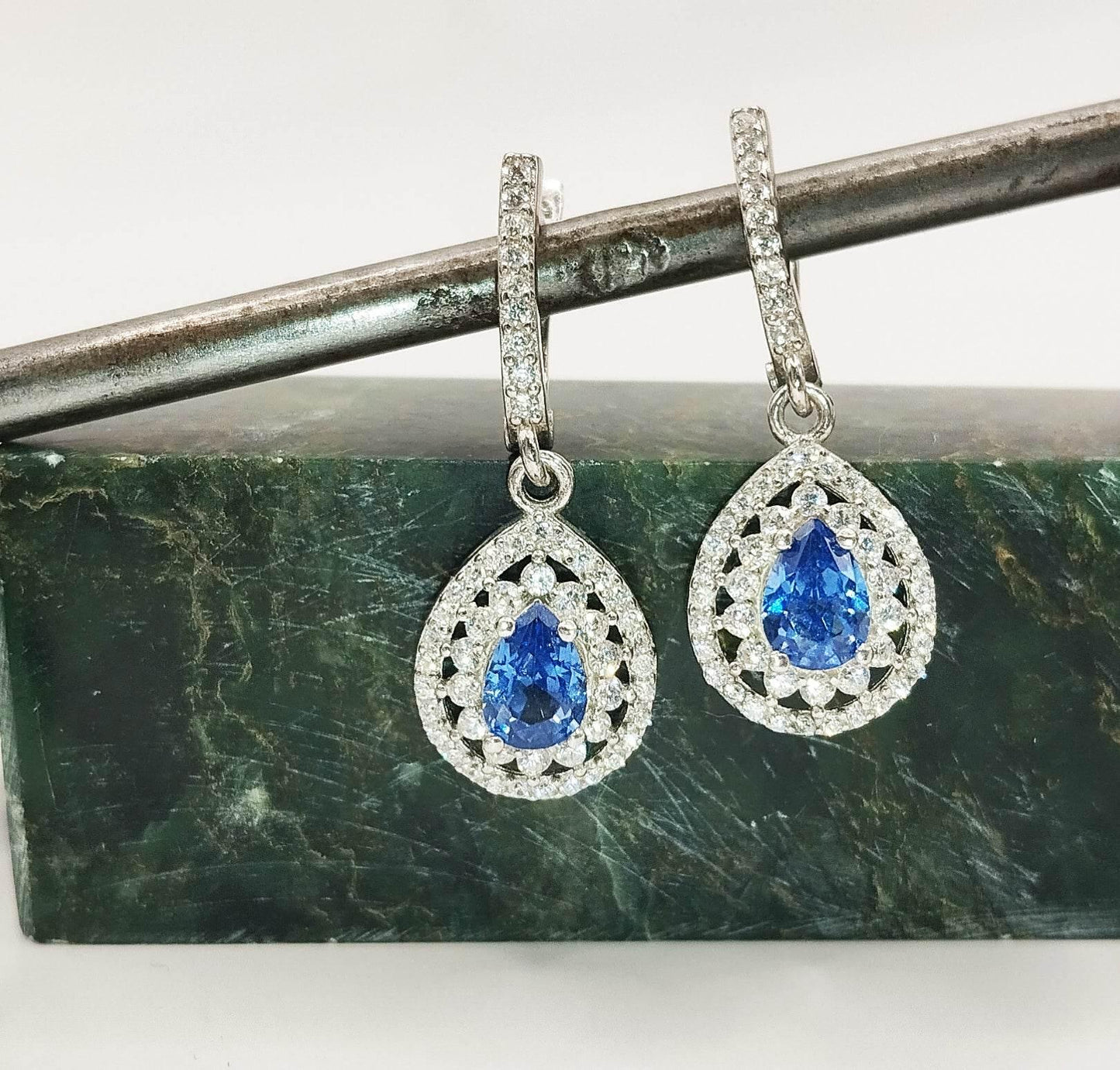 Ασημένια σκουλαρίκια με μπλε "σταγόνα" από ζιργκόν και λευκά ζιργκόν τριγύρω και πάνω από το μπλε στοιχείο.
Ιδανικά για βραδινές εμφανίσεις χάρη στην εντυπωσιακή τους λάμψη.