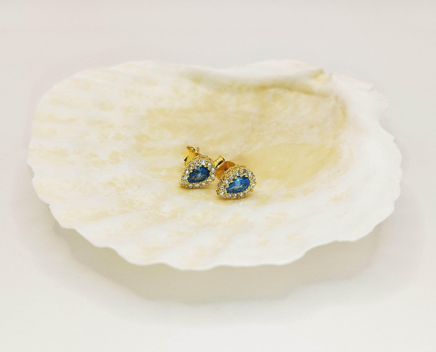 Σκουλαρίκια καρφάκια από επιχρυσωμένο ασήμι με γαλάζια και λευκά ζιργκόν σε σχήμα σταγόνας.
Λαμπερά και υπέροχα.