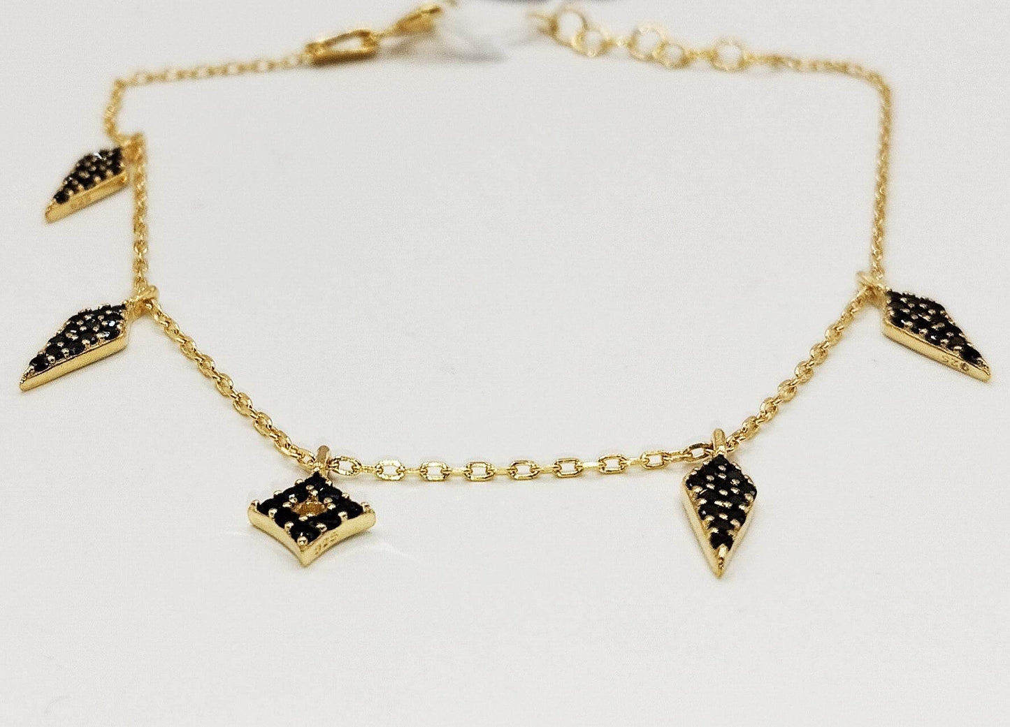 Βραχιόλι από επιχρυσωμένο ασήμι με γεωμετρικά στοιχεία στολισμένα με μαύρα ζιργκόν.
Τα μαύρα ρομβοειδή στοιχεία κάνουν αυτό το κομψό βραχιόλι πιο ανάλαφρο.