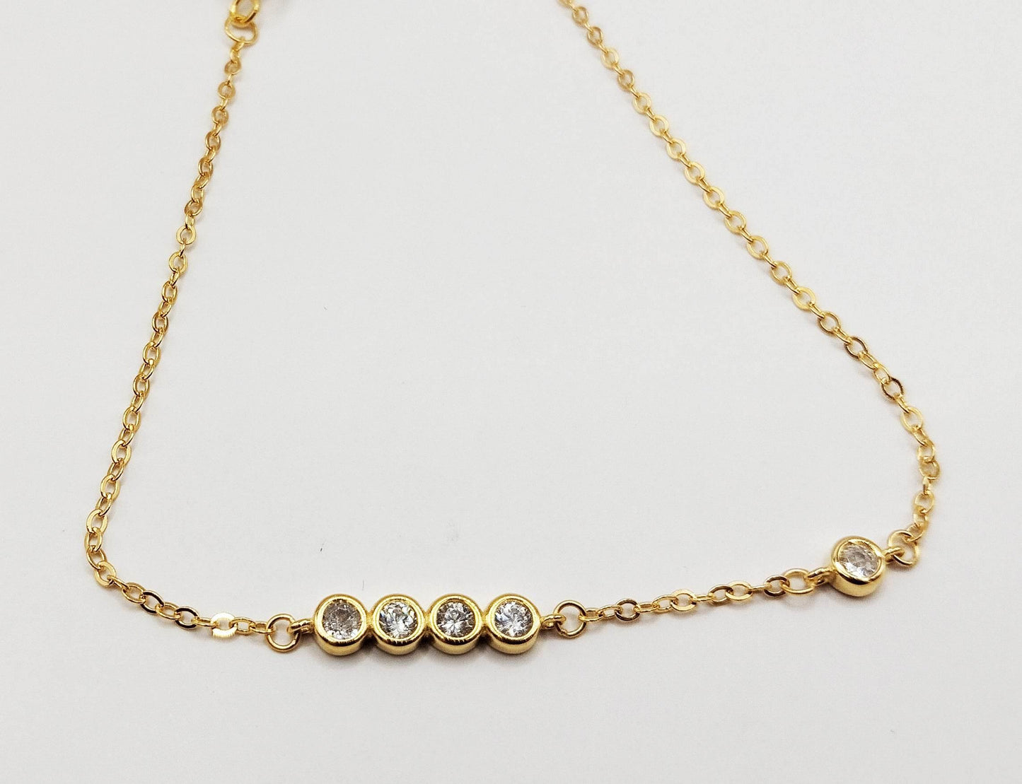 Βραχιόλι από επιχρυσωμένο ασήμι με μια σειρά από λευκές πέτρες ζιργκόν.
Απλό και κομψό.