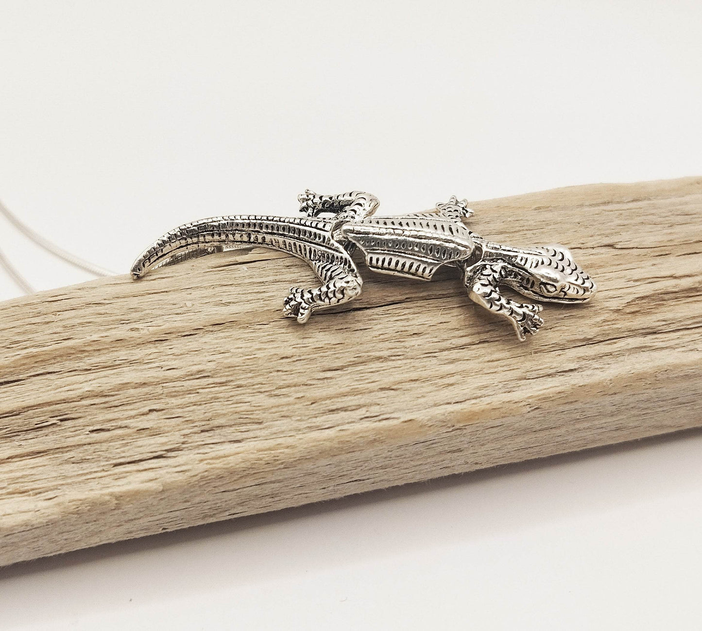 Ασημένιο κολιέ με ασημένιο μενταγιόν σε σχήμα σαύρας.
Το σώμα της σαύρας είναι κινούμενο.